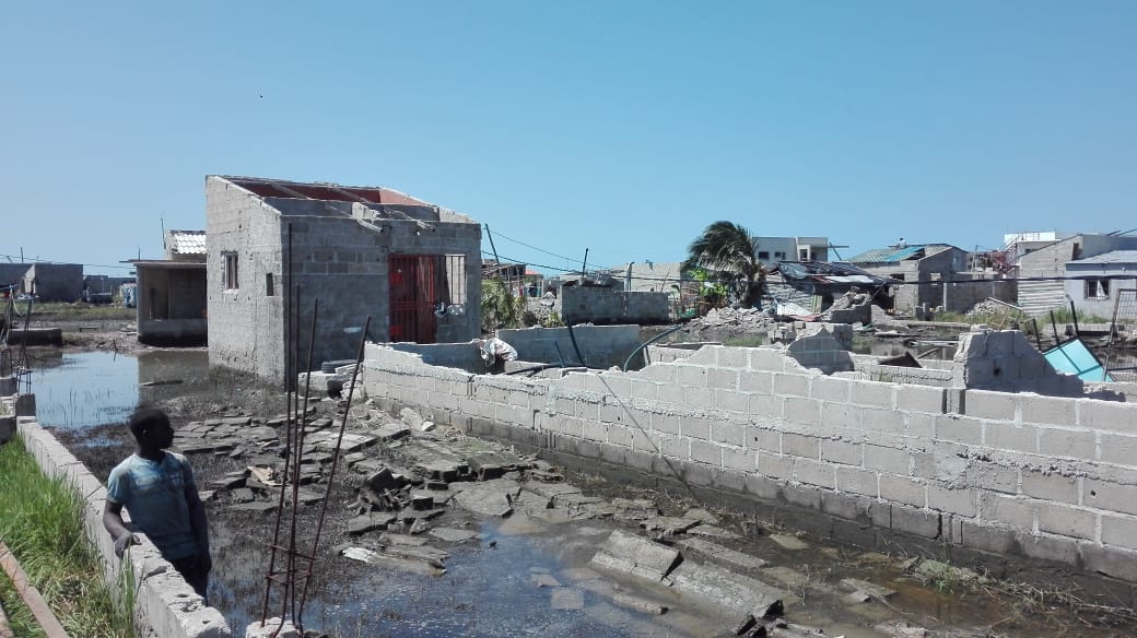 Man arm on wall by ruined house